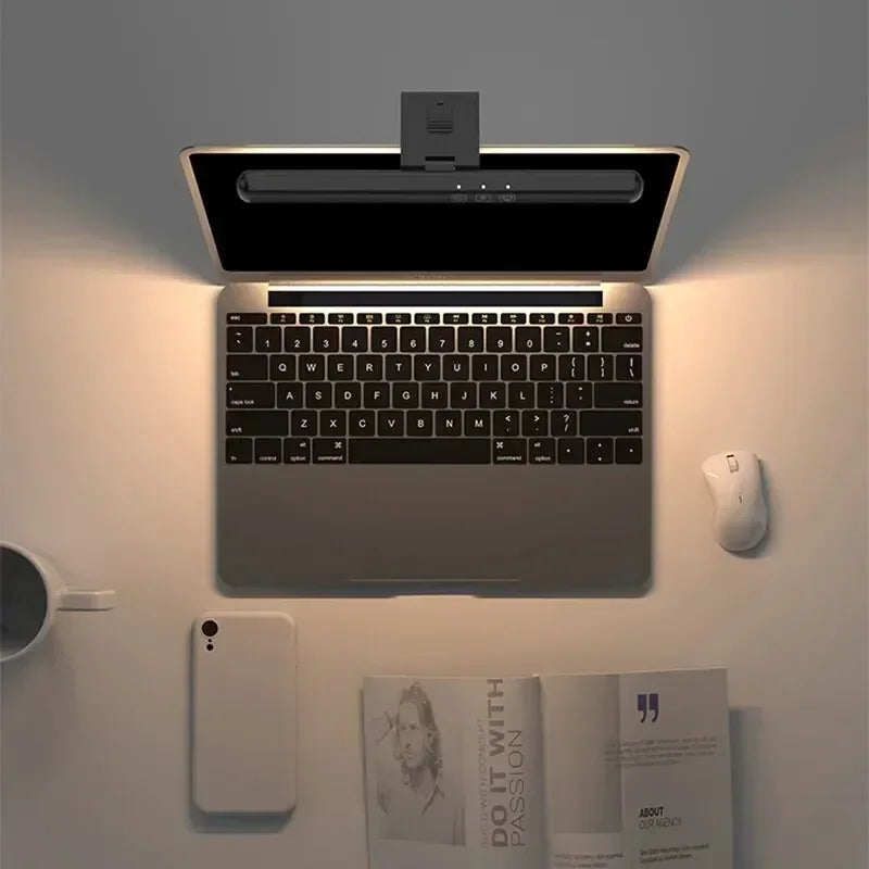 Luminária LED para monitor FocusBar instalada em notebook destacando a iluminação da área de trabalho visto de cima.