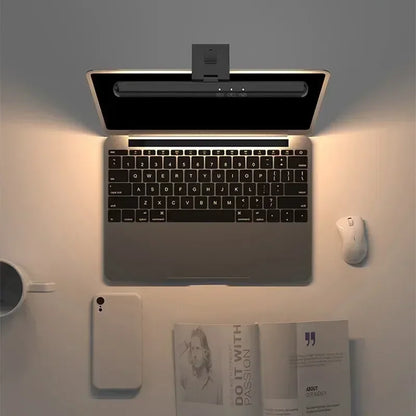 Luminária LED para monitor FocusBar instalada em notebook destacando a iluminação da área de trabalho visto de cima.