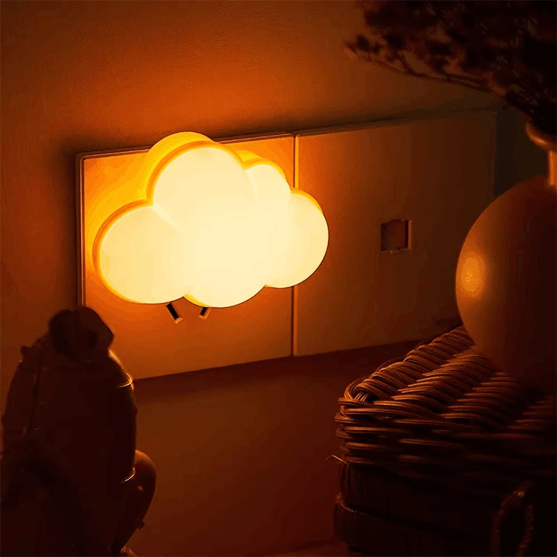 Luminária de Parede em formato de nuvem DreamCloud no quarto emitindo luz amarela suave na tomada.