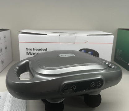 Visão técnica do Massageador Elétrico destacando o design ergonômico e botões de intensidade, com caixa ao fundo.