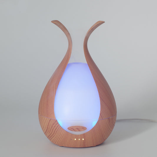 Umidificador de ar Sillencia BloomMist em textura amadeirada com luz azul interna e névoa suave.