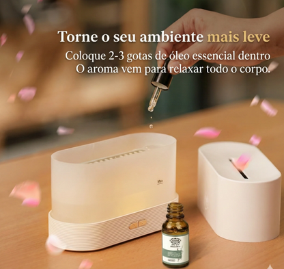 Umidificador de ar FlameGlow em uma mesa aberto com conta gotas pingando óleo essencial.