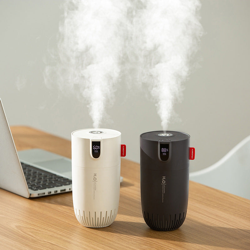 Dois umidificadores de ar Sillencia NomadMist em cores branco e preto liberando névoa suave sobre uma mesa.
