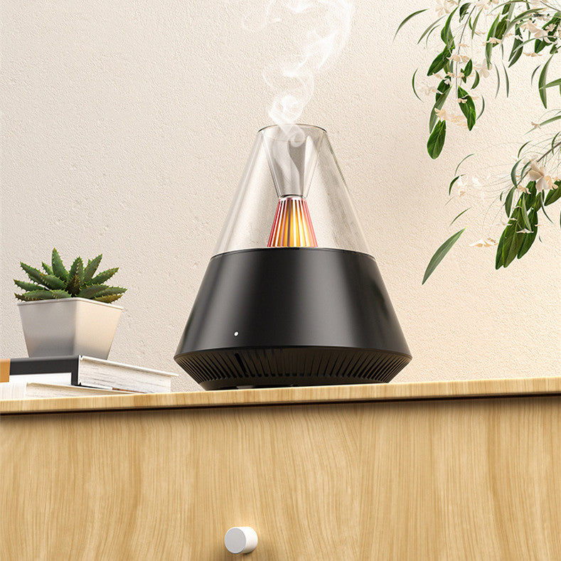 Umidificador de ar Sillencia VolcanoMist em preto liberando névoa com luz de chama interna em uma mesa.