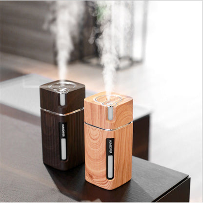 Umidificador de ar Sillencia WoodMist em textura amadeirada clara e escura liberando névoa fina em cima de uma mesa.