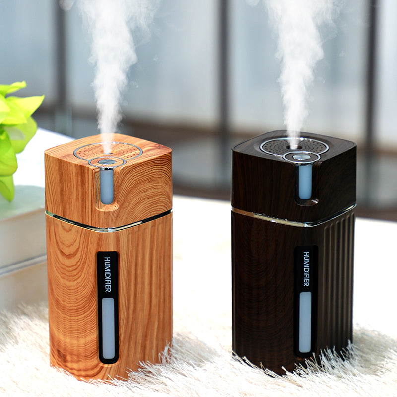 Umidificador de ar Sillencia WoodMist em textura amadeirada clara e escura liberando névoa fina em ambiente aconchegante