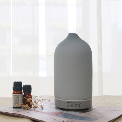 Umidificador de ar Sillencia ZenMist Ceramic em cinza com óleos essenciais ao lado